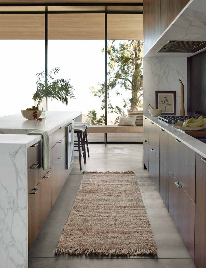 #size::2-6--x-8- | The Hagan rug in its runner size lays in a kitchen with stone countertops and floor to ceiling windows