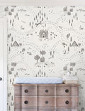| The Through the Woods Wallpaper is in a room with a six drawer distressed wooden dresser with a changing station atop it